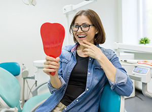 Young woman admiring her new dental implants in Meriden