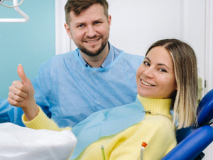 Happy dental patient making thumbs up gesture