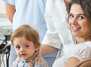 Woman in dental chair with child in lap