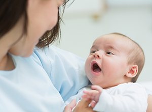 Mother holding baby with lip tie