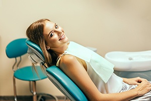 Happy dental patient reclining in treatment chair