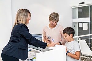 Dental team member assisting family at front desk