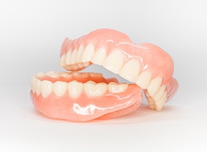 Upper and lower dentures isolated against neutral background