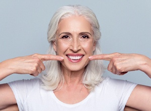 Smiling senior woman with implant dentures in Meriden