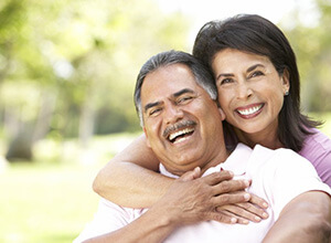 Smiling couple with dental implants in Meriden