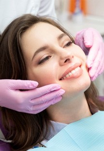 patient smiling while looking in dental mirror  