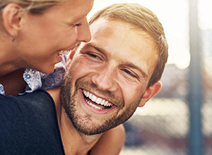 man giving woman piggyback laughing