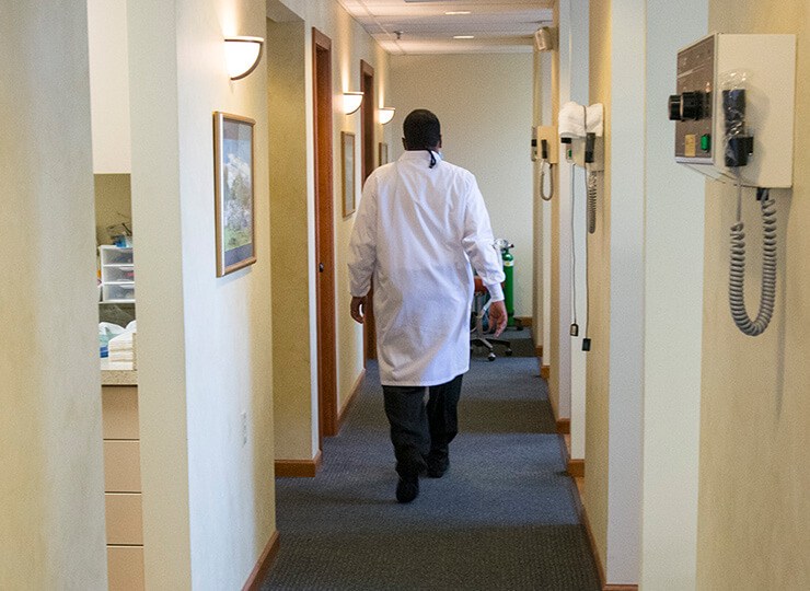 Dentist walking down hall to treatment rooms