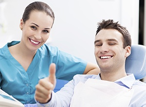 Man in dental chair giving thumbs up