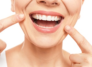 Woman showing straight teeth after using orthodontics in Meriden