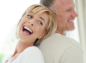 woman laughing behind man's back