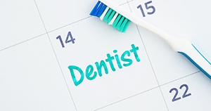 Toothbrush on calendar, dental appointment marked on calendar