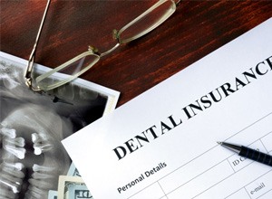 Dental insurance form with glasses, pen and X-ray