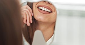 Dental patient’s beautiful smile reflected in mirror