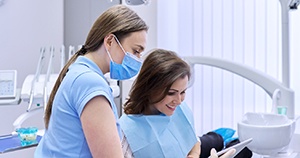 Patient and dental team member conversing over iPad
