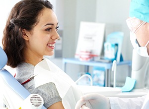 Smiling woman talking to dentist in treatment room