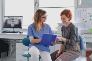 Dentist and patient reviewing paperwork together 