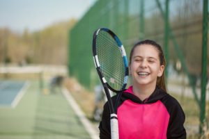 Smiling, athletic teen girl with undergoing orthodontic treatment in Meriden