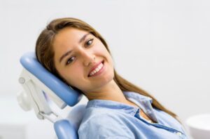Smiling dental patient reclining in treatment chair