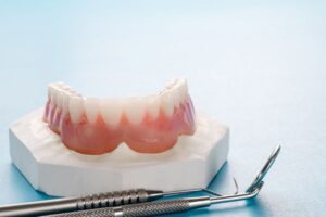 Lower denture next to dental instruments