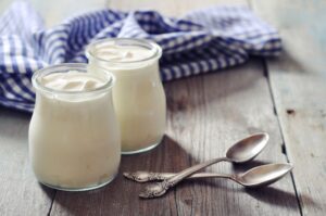 Two small jars of yogurt sitting on table